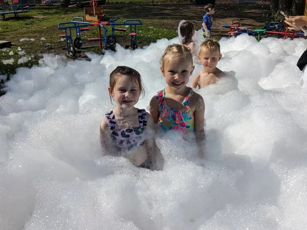 Toddlers laughing in foam at a daycare
